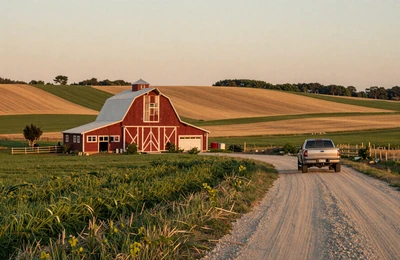 American farmland patchwork at golden hour with red barn and rolling fields