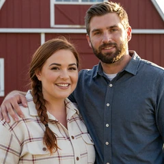 Hannah and Caleb, Iowa farm couple smiling together in a red barn